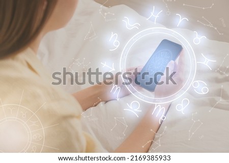 Woman with smartphone reading daily horoscope indoors, closeup Royalty-Free Stock Photo #2169385933