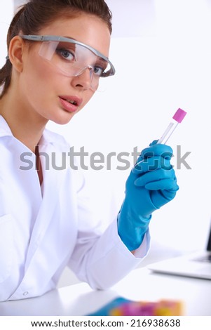 Woman researcher is surrounded by medical vials and flasks, iso