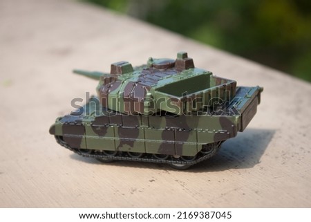 Toy tank with camouflage color . Military vehicles toy. Simple cheap toys for children , warfare, warzone vehicles, kids playing war, abstract concept nobody