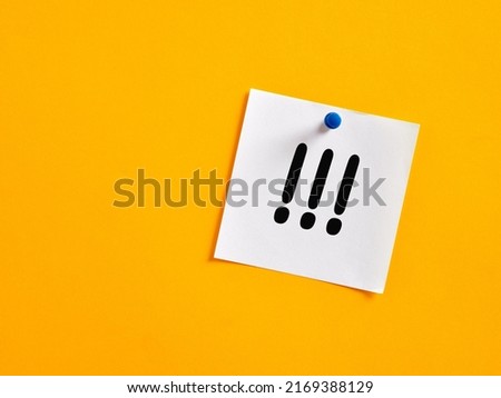 Three handwritten exclamation marks on a note paper pinned on a yellow board. Important notice concept. Royalty-Free Stock Photo #2169388129