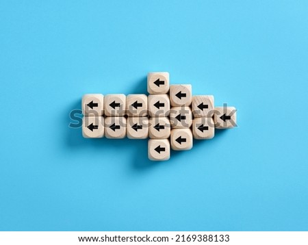 Arrow icon made of wooden cubes with little arrow icons pointing opposite direction. Resistance to change in business concept. Royalty-Free Stock Photo #2169388133