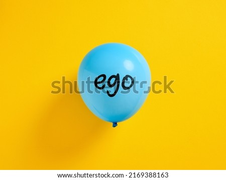 Inflated blue balloon with the word ego and a pin. Selfishness or inflated extreme ego concept. Royalty-Free Stock Photo #2169388163