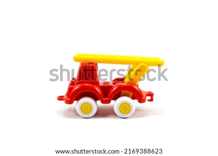 Red paint plastic toy fire truck with yellow ladder isolated on white background
