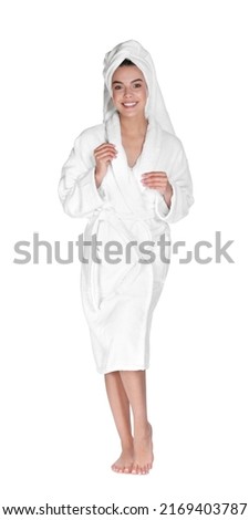 Beautiful young woman wearing bathrobe and towel on head against white background Royalty-Free Stock Photo #2169403787