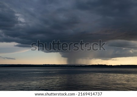 Dramatic sunset with stormy sky and rain over the Constance lake, Germany