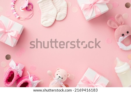 Baby girl concept. Top view photo of gift boxes socks booties knitted bunny rattle toy teddy-bear pacifier chain bottle and confetti on isolated pastel pink background with copyspace in the middle