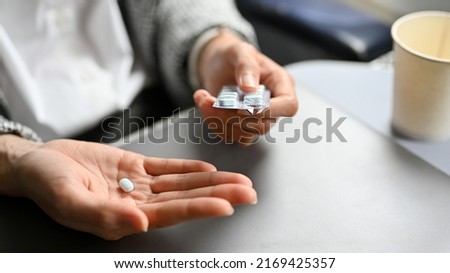 Close-up image, An airsick motion sickness pill on a female hand. Healthcare and transportation concept. Royalty-Free Stock Photo #2169425357