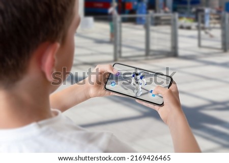 Boy programs and controls the robot on the street via augmented reality technology concept Royalty-Free Stock Photo #2169426465
