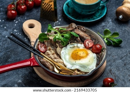 Keto diet breakfast or lunch dish Baked sweet purple potatoes, grilled bacon and fried egg in pan and coffee. Healthy fats, clean eating for weight loss, top view.