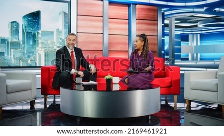 Talk Show TV Program and News Discussion: Two Charismatic Presenters Talk, Have Fun. Cable Channel Hosts Have Friendly Conversation. Morning, Breakfast Television Entertainment in Studio Concept Royalty-Free Stock Photo #2169461921