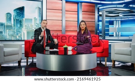 Talk Show TV Program and News Discussion: Two Charismatic Presenters Talk, Have Fun. Cable Channel Hosts Have Friendly Conversation. Morning, Breakfast Television Entertainment in Studio Concept Royalty-Free Stock Photo #2169461925