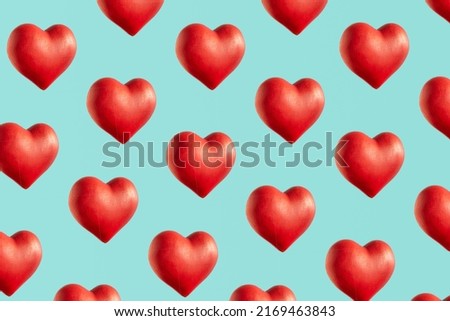 Red hearts, creative pattern against bright blue background. Love and passion inspired. 