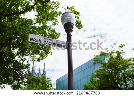 Wolfe-Montcalm avenue sign on street light with church tower and building in soft focus background, Quebec City, Quebec, Canada