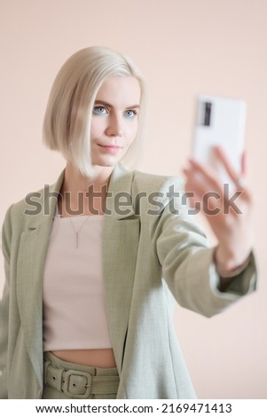 Young woman taking selfie on smartphone.
