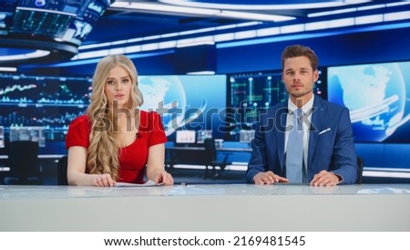 TV Live News Program: Two Presenters Reporting, Discuss Daily Events, Business, Economy, Science, Entertainment. Television Cable Channel Diverse Anchors Talk. Newsroom Studio Concept Royalty-Free Stock Photo #2169481545