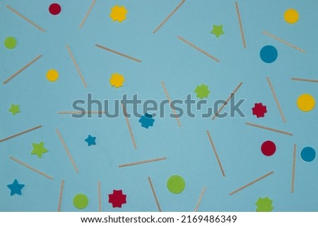 pastel blue background with wooden sticks and colorful geometric shapes, creative summer background
