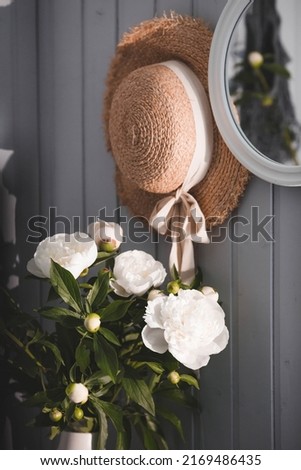 A beautiful white bouquet of peonies in the sunlight on a black table. The interior of a country house in the style of Provence. The concept of home comfort and decor in the house.