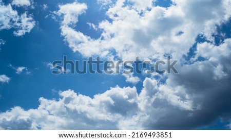 White and gray clouds in the blue sky. A change in the weather. Background image