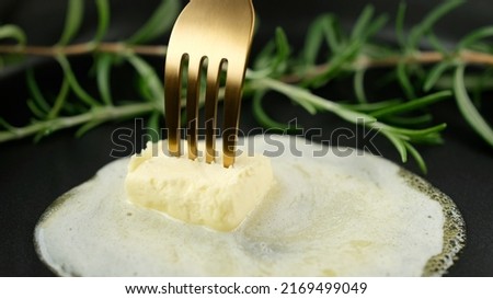 Butter and rosemary in pan. Melt butter in a pan. Butter Slice is Melting and Sizzling on a Frying Pan Royalty-Free Stock Photo #2169499049