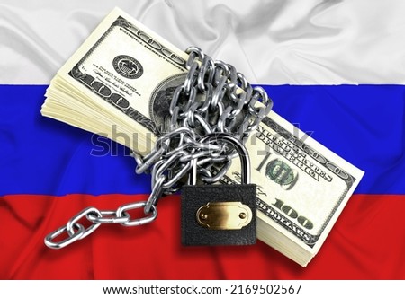 Dollars, lock on the background of the Russian flag. Monetary crisis, financial problems, sanctions, default. The concept is up-to-date relevant situation in economics and politics. Royalty-Free Stock Photo #2169502567