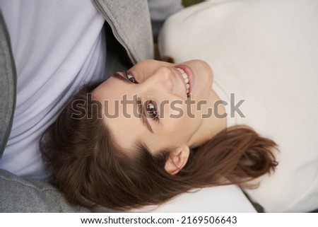 Happy young woman resting on man laps during date