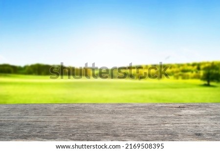 Wooden table top on blur mountain and grass field.Fresh and Relax concept.For montage product display or design key visual layout.View of copy space.