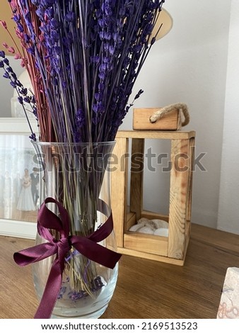 Pink and purple lavender in the vase. A family picture at the behind. A nostalgic and vintage picture