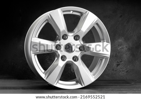 a new powerful six-spoke alloy wheel in silver color on a dark textured background. auto parts for SUVs and crossovers. Royalty-Free Stock Photo #2169552521