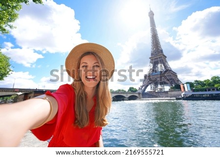 Young tourist woman making selfie photo with Eiffel tower on the background in sunny day in Paris, France Royalty-Free Stock Photo #2169555721