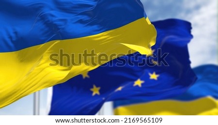 the national flag of Ukraine waving with blurred european union flag on a clear day. Democracy and politics.