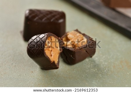 Brown chocolate with bisected chocolate on isolated background. Half chocolates include peanuts. Concept chocolate picture. Delicious chocolates. 