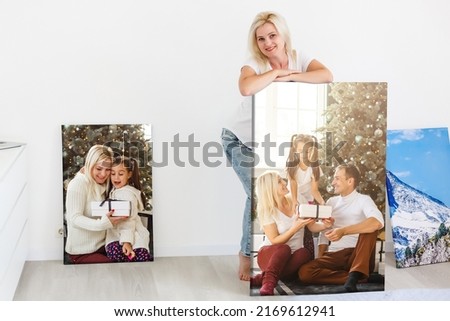 woman holding photo canvas on the background of a interior