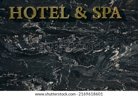 resort hotel and spa signboard on gray stone wall background. Entrance sign " Hotel and Spa" .