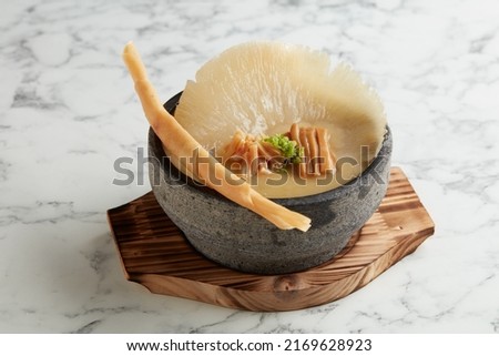 Premium Shark Fin in Supreme Broth accompanied with Crispy Sping Roll served in Japanese Stone Pot served in a dish isolated on grey background