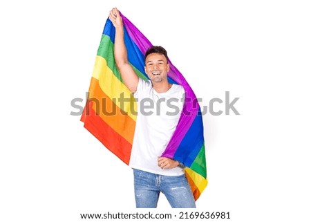 Portrait of a smiling young gay man holding a lgbtqi flag Isolated on a white background