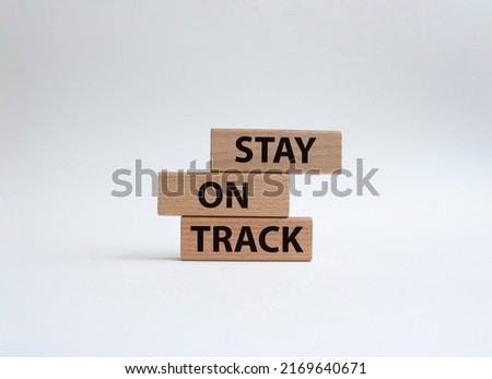 Stay on track symbol. Wooden blocks with words 'Stay on track'. Beautiful white background. Business and 'Stay on track' concept. Copy space.