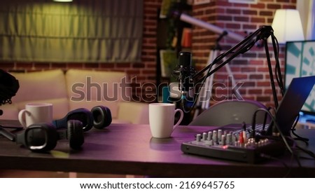 Nobody in podcast home studio with microphone boom arm and audio recording professional mixer on desk. Empty internet online radio setup for producing podcasts for social media. Royalty-Free Stock Photo #2169645765