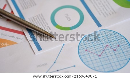 Close-up of metal pen on documents with colourful charts, graphs and diagrams. Planning business documents. Financial strategy calculation. Accountant analysis concept Royalty-Free Stock Photo #2169649071