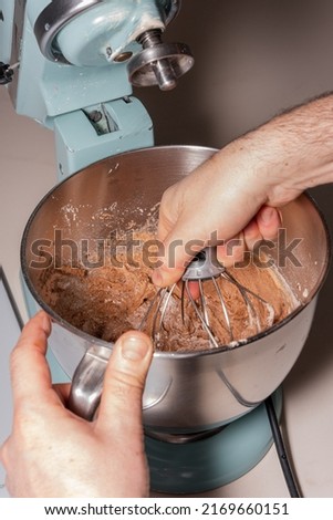 Hands of a man cooking a red velvet cake at home, preparing the cake by adding cocoa powder with flour and yeast in the food processor, work at home