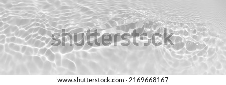 Water texture with wave sun reflections on the water overlay effect for photo or mockup. Organic light gray drop shadow caustic effect with wave refraction of light. Long Banner with copy space. Royalty-Free Stock Photo #2169668167