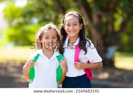 Kids go back to school. Interracial group of children of mixed age run and cheer on the first day of new academic year. Start of school holiday. Preschooler or kindergarten kid. Child in school yard. Royalty-Free Stock Photo #2169683145