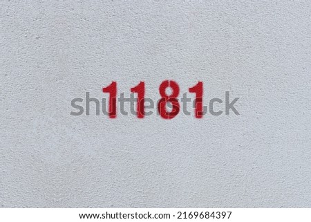 Red Number 1181 on the white wall. Spray paint.
