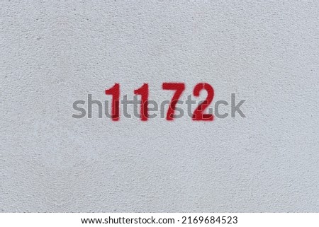 Red Number 1172 on the white wall. Spray paint.

