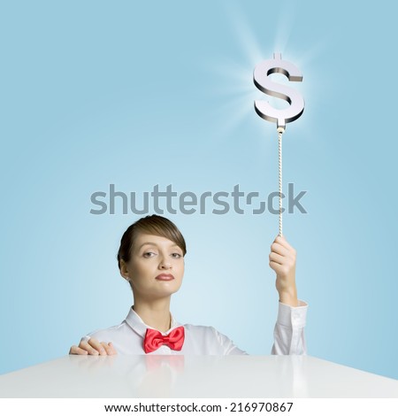 Young woman holding balloon shaped like dollar sign