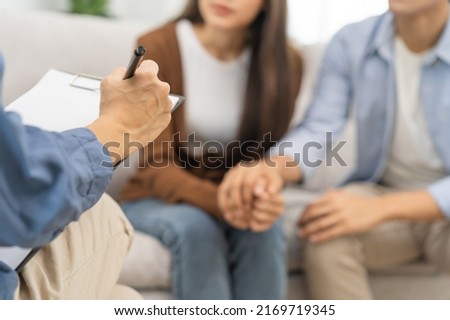 Psychology, depression asian young couple, patient consulting problem mental health with psychologist, psychiatrist at clinic together, husband encouraging by holding hand of wife, therapy health care Royalty-Free Stock Photo #2169719345