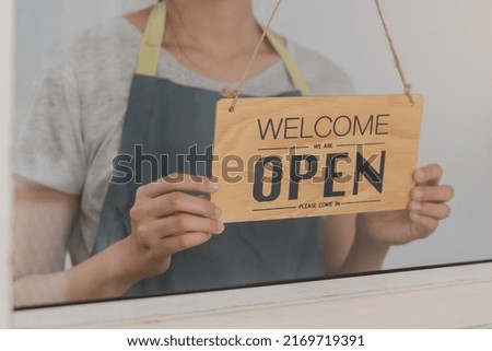 Owner business retail, asian young woman hand in turning sign board to open coffee shop, reopen store after close lockdown quarantine in covid-19.