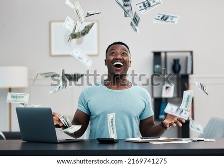 Its raining money. Shot of a young businessman managing his money at home.