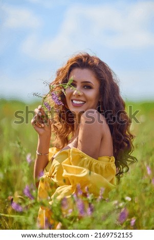 Attractive woman in a poppy field with flowers in full bloom.