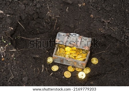 Treasure chest and gold coins in underground where the soil was dug Royalty-Free Stock Photo #2169779203