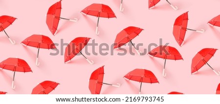Many red umbrellas on pink background. Pattern for design